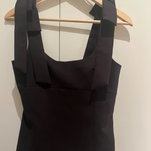 Svart topp med rosett från Zara - Skitsnygg svart festtopp från zara!! Säljs för att jag ibte använder den längre. Den är använd få gånger i sommar, tvättad kanske 5 gånger. Finns inte i butik längre eller på nätet🥰❤️