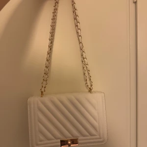 Väska - Super fin väska som går att matcha med allt. Man får plats med lite småsaker som telefon, nycklar, plånbok och lite smink. Liten fläck som syns på bild 2