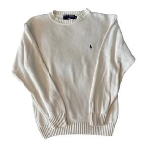Vit stickad tröja Polo Sport - Snygg vit stickad tröja från Polo Sport Ralph Lauren med klassisk rund hals och diskret logobroderi på bröstet. Perfekt för dig som gillar clean och stilren look.