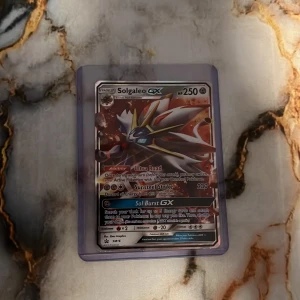 Solgaleo GX - Solgaleo GX är ett samlarkort från Pokémon-serien med coolt holografiskt motiv och kraftfulla attacker. Perfekt för dig som älskar Pokémon och vill boosta din samling med ett unikt och snyggt kort. Kortet är skyddat i plastficka och passar både samlare och spelare.