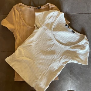 2-pack ribbade toppar i beige och vitt - Säljer två ribbade toppar från H&M i storlek S. Ena toppen är beige och den andra är vit, båda med rund halsringning och kort ärm. Perfekta att matcha med jeans eller kjol. KÖP 1 för 50kr, båda för 80 kr. Priset går att diskutera!!!