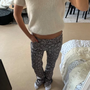 Weekday snakeprint bootcut byxor - Säljer ett par snygga bootcut-byxor från Weekday i storlek 38. Har används max 1 gång!