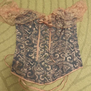 Rapunzel korsett - Rosa och lila lila korsett med spets och knytning baktill. Perfekt om man ska klä ut sig till tex rapunzel på halloween!!