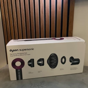Dyson Supersonic - Dyson Supersonic hårfön i originalkartong med flera tillbehör: stylingkoncentrator, smoothing nozzle, diffuser, gentle air och flyaway attachment. Snabb torkning utan extrem värme. Helt Ny