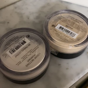 Isadora Loose Setting Powder duo - Två burkar Isadora Loose Setting Powder, en i färgen 00 Translucent och en i 03 Fair. Båda kommer i runda plastburkar med svart lock. Perfekt för att fixera sminkbasen och ge en matt finish. Lätta och silkeslena puder som smälter in i huden.