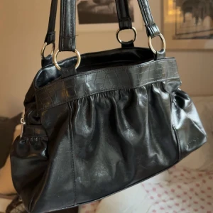 Svart axelväska i skinnimitation - Köper ni innan 19 postar jag samma dag!! Snygg svart väska som inte kommer till användning! Vill bli av med saker snabbt så skicka prisförslag💓