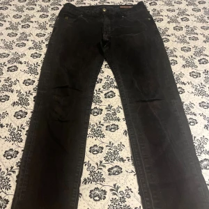 Svarta manchesterbyxor Replay - Snygga svarta manchesterbyxor från Replay med klassisk femficksdesign och raka ben. Byxorna har en diskret logga vid fickan och är tillverkade i mjuk manchester som ger en cool och retro vibe. Perfekta för dig som gillar stilrena och bekväma byxor.