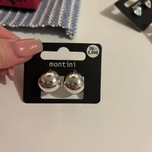 Två par silvriga örhängen - Säljer ett par coola silvriga från monotoni. Perfekta för att lyfta din look med en trendig touch. Jag har aldrig testat dom så är helt nya och oanvända!!