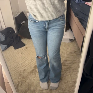 Blå bootcut jeans  - Säljer ett par ljusblå bootcut jeans från Dr Denim med klassisk femficksdesign och slitning vid ena knät. Jeansen har hög midja och raka ben med lätt utsvängd form. Perfekt för dig som gillar en avslappnad och trendig look. Priset kan diskuteras 