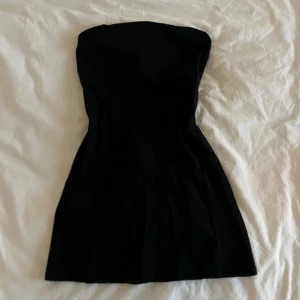 Svart miniklänning Pull&Bear M - Svart, och axelbandslös klänning från Pull&Bear i storlek M men passar S mycket bra. Den har lite kostym stil, har stretchigt tyg och dragkedja i ryggen. Tror jag aldrig har använt den så den är i nyskick 