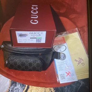 Gg väska  - Snygg svart magväska från G med klassiskt GG-mönster och dragkedja. Väskan har en praktisk ficka framtill och justerbart band. Perfekt för att bära det viktigaste med stil och attityd.