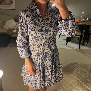 Blåvit blommig kortklänning Gina Tricot - Supersöt kortklänning från Gina Tricot i blått och vitt med blommigt mönster. Storlek xs!