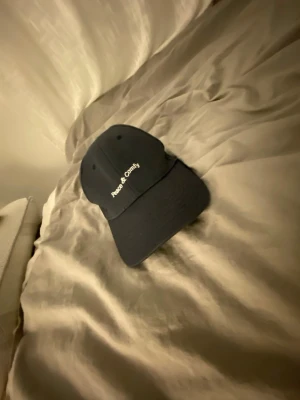 Mörk blå keps Peace & Comfy - Snygg mörk blå  keps från lager57  med böjd skärm och broderad vit text framtill. Klassisk design med ventilationshål och justerbar passform. Perfekt accessoar för en avslappnad streetstil.