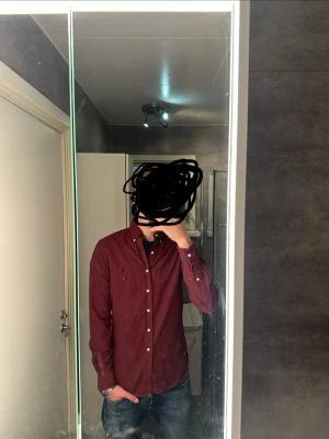 Ralph Lauren skjorta - Säljer en vinröd skjorta från Ralph Lauren med klassisk button-down krage och broderad logga på bröstet. Perfekt för dig som vill ha en stilren och tidlös look. Skriv vid frågor och kolla gärna in min profil för potentiella bundles!