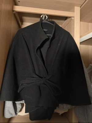 Svart ponchojacka från Missäy - Nytt skick utan prislapp men har dock tagit bort den guldiga knappen. Det går att sy fast en!