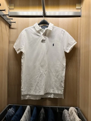 Polo Ralph lauren  - Vit polo Ralph lauren tröja. Vit polo med snygg krage. Den är lite längre där bak med ”hål” på sidorna. Riktig snygg polo till sommaren. Kan absolut tänka mig gå ner i pris vid snabb affär😊