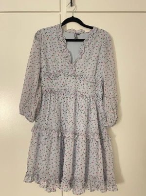 Ljusblå blommig volangklänning pieces  - Aldrig använd, inga defekter 