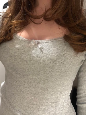 Ljusgrå ribbad långärmad topp - Supersöt spetstopp med en liten rosett 🎀 Endast använd fåtal gånger!