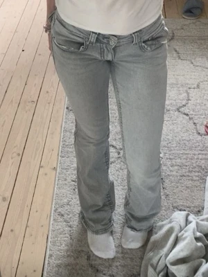 Ljusgrå bootcut jeans med låg midja Gina - Säljer dessa jätte snygga Low Waist jeans från Gina tricot med knappar bak.💗 Köptes maj 2025 