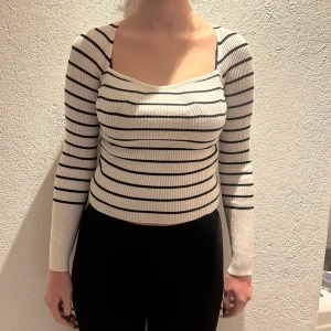 Randig ribbad topp - Trendig långärmad topp med svart-vita ränder och ribbad struktur. Passar perfekt till höga byxor eller kjol. Använd max 3 gånger.