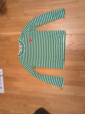 Comme des garcons tröja  - Säljer en grön och vit randig långärmad topp från Comme des Garçons Play. Skriv för fler bilder/frågor😊Bättre pris vid snabb affär:)