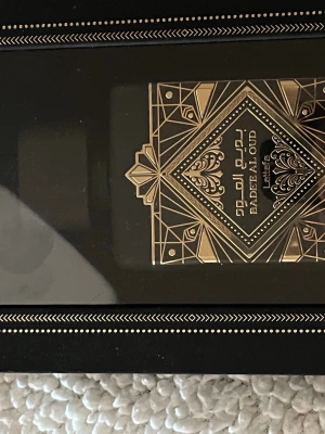 Lattafa Badee Al Oud Oud For Glory helt ny  - Lattafa Badee Al Oud Oud For Glory är en lyxig parfym med svart och guld dekorativ flaska. Flaskan har geometriska och orientaliska mönster i guld, vilket ger en exklusiv känsla. Perfekt för dig som gillar orientaliska dofter och snygg design. HELT NY