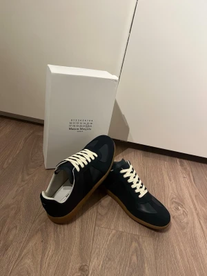 Maison Margielas Navy - Maison margiela gats. Storlek 43. Färgen navy Inte använda. Box medföljs och de skickas samma dag eller dagen efter! Hör av er vid frågor