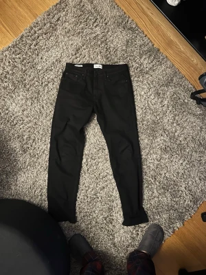 Jack & Jones svarta Regular/Clark jeans - Ett par feta svarta jeans från Jack & Jones köpta på Drottninggatan för runt ett år sen. Har ej använt de mycket vilket är anledningen till att jag säljer de. De har inga slitage eller fläckar. Skriv för fler bilder. 