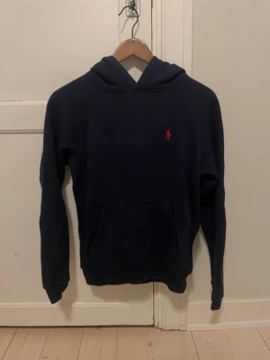 Ralph Lauren Hoodie - Marinblå Ralph Lauren hoodie med en röd ponny logga🐎  Storlek S. Mått finns på de tre sista bilderna📏  I perfekt skick, inga hål, fläckar eller liknade✨  Priset går såklart att diskutera så kom med förslag😊
