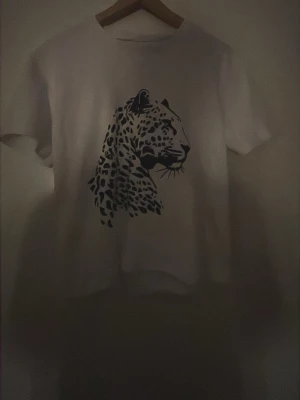 Vit egengjord t-shirt med leopardtryck - Snygg egengjord vit tröja med ett leopard tryck på framsidan. Den har en trendig look som ger en extra bra vibe. Hör gärna av er om ni vill ha bättre bilder💞