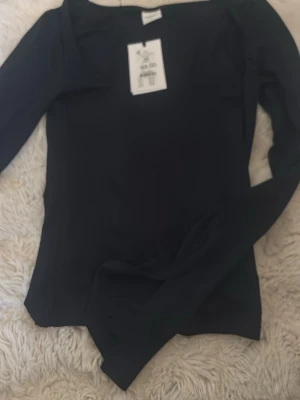 Mörkblå långärmad topp XS elevated basics - Säljer en mörkblå långärmad topp från Gina trickot men köpt på Ullared  i modellen 'Soft touch jersey top'. Toppen har en enkel, stilren design med rund halsringning och är gjord i ett mjukt, stretchigt material som känns skönt mot huden.