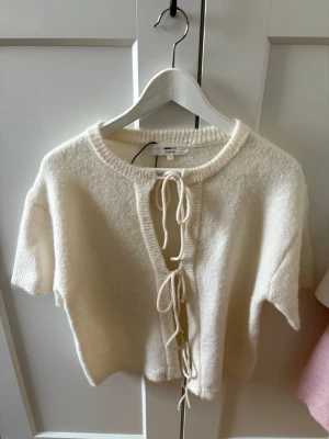 Stickad  - Vit stickad t-shirt med knytningar i fram storlek xs från Gina tricot