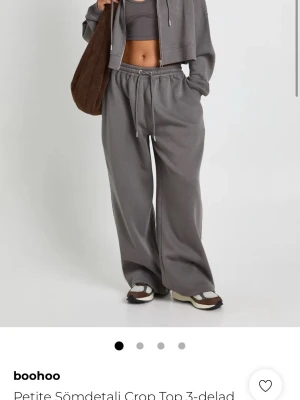 Grå mjukisset  från Boohoo - Säljer ett mjukisset från Boohoo med bred passform och dragsko i midjan. Byxorna har en loose fit och är tillverkade i mjukt bomullsmaterial, perfekta för en chill och avslappnad stil. Jag säljer den då den är lite för liten för mig och jag är en 168 och den var lite för kort. Aldrig använt den ny och har kvar prislapp.