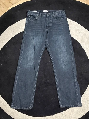 Jack & Jones Loose Fit Jeans 28/30 - Mörkblå loose fit jeans från Jack & Jones, modell Chris. Klassisk femficksdesign med raka ben och normal midja. Tillverkade i slitstarkt denimtyg som ger en avslappnad och trendig look. Perfekta för dig som gillar en lite mer relaxed passform.