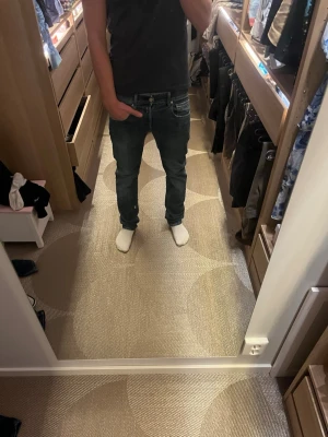 Replay Grover jeans  - Säljer ett par Replay Grover jeans i klassisk blå tvätt med straight fit. Dem är i storlek 28/30 och han på bilden är 172 och väger runt 63 kg. Jeansen har fem fickor, normal passform och snygga slitningar för en avslappnad look. Tillverkade i slitstarkt jeansmaterial och passar perfekt till vardagsstilen.