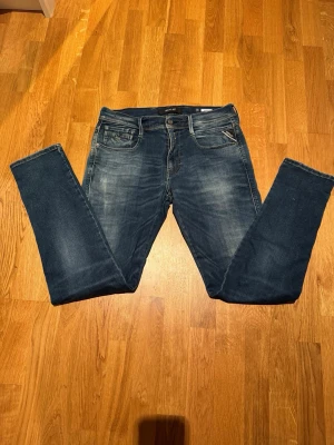 Replay Anbass jeans - Säljer ett par Replay Anbass jeans i klassisk blå tvätt, snygga kontrastsömmar och lite sköna slitningar. Mjuk och stretchig slim fit modell i väldigt bra skick! Storlek 32 32