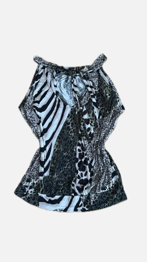 Y2K topp - Säljer en snygg topp med både zebra- och leopardmönster i svart, vit och grön ton. Toppen har knyt i halsen och är ärmlös med en smickrande passform. Materialet är mjukt och följsamt, perfekt för dig som gillar djurprint och vill sticka ut. Storlek står inte men skulle säga att den ligger mellan S och M. 