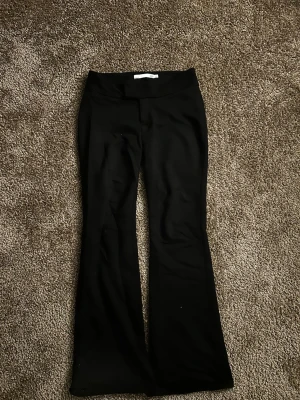 Svarta bootcut byxor från lager 157 XS - Säljer ett par svarta Lågmidjade bootcut kostymbyxor från lager 157 i storlek XS. De har två hål vid midjan kolla bild tre