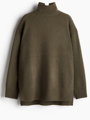 Olivgrön polotröja i ullmix - Säljer en olivgrön polotröja med hög ribbad krage och breda muddar. Tröjan har en loose passform och är tillverkad i mjuk ullmix, perfekt för kyliga dagar. Enkel och stilren design som är lätt att matcha.