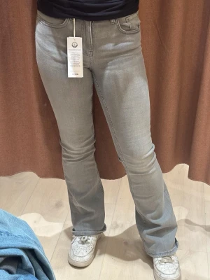 Grå bootcut jeans - Snygga grå jeans med bootcut-modell och klassisk femficksdesign. Jeansen har en stilren look och är tillverkade i mjukt denimtyg som sitter skönt. Den är aldrig använda utan bara testande. 