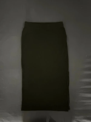 Svart ribbad kjol från only - Svart långkjol från only i storlek XS. Kjolen är ribbad och har en slits på vänstra sidan. Enkel design och går lite längre än ner till knäna (på mig som är 166cm). Väldigt skön och stretchig men lite nopprig, säljer eftersom den inte kommit till användning