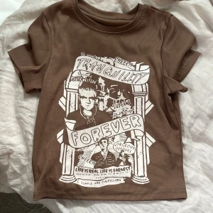 Trendig brun ribbstickad T-shirt med unikt tryck - Säljer en riktigt snygg brun ribbstickad T-shirt med unikt tryck.