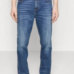 Blå jeans REPLAY SANDOT relaxed tapered 33/30 - Snygga blå jeans från Replay med klassisk femficksdesign och subtila slitningar. Inga hål. Dragkedja. Perfekta för en avslappnad skön bekväm  stil. Avsmalande ben nertill.   Storlek: Midja:33 Längd:30                     