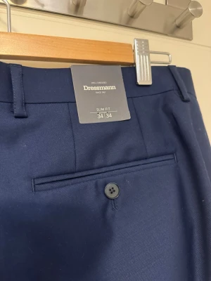 dressman byxor - Säljer dessa byxor från dressman. De är helt nya med prislapp på och kostar 800kr nya, de är i storlek 34/34. De är stiliga och perfekt att ha till jobbet eller när man ska klä upp sig! pris kan diskuteras