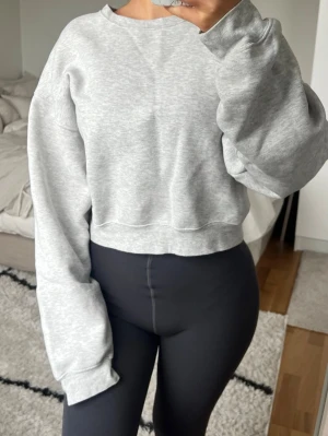Grå croppad sweatshirt från BikBok - Långärmad ljusgrå cropped tröja från Bik Bok i storlek XS. Har en svag missfärgning på ärmen <3