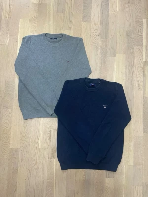 GANT stickade tröjor – navy & grå – paketpris 499 kr - Säljer två klassiska GANT crewneck-tröjor som paket – perfekt bas i garderoben 🍂  Paketet innehåller: • 1 st marinblå GANT-tröja • 1 st grå GANT-tröja  Båda har diskret GANT-logga på bröstet och tidlös, preppy/skandinavisk stil. 	•	Märke: GANT 	•	Modell: Crewneck / stickad tröja 	•	Passform: Regular 	•	Skick: Bra begagnat skick, normalt slitage 	•	Passar perfekt till vardag, jobb, skola eller casual outfits  💰 Paketpris: 499 kr för båda 📦 Skickas snabbt 💬 Hör av dig vid frågor!