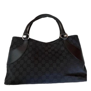 Gucci vintage väska – autentiserad - Gucci vintage väska – autentiserad  Snygg och tidlös Gucci-väska från början av 2000-talet i klassisk GG monogram canvas med läderdetaljer. En exklusiv och elegant modell som passar både till vardags och fest. Väskan är autentiserad via Vestiaire Collective och garanterat äkta.  Mått: bredd cirka 36 cm, höjd 20 cm, djup 6 cm. Väskan är i fint vintage-skick, lätt använd men välbevarad.  Nypris för liknande modeller ligger betydligt högre men säljes nu för 4 500 kr (vid snabb affär kan priset disk