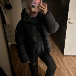 Svart pufferjacka från Colmar - Säljer en svart pufferjacka från Colmar med huva och dragkedja. Oversized, jag är 157😍 Mycket sparsamt använd. Storlek 40 om jag tolkar lappen rätt