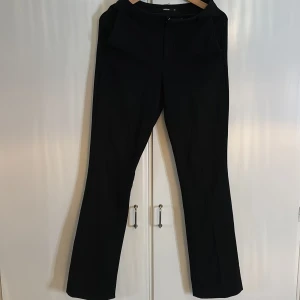 Svarta kostymbyxor med diskreta ränder - Snygga svarta kostymbyxor från bikbok med diskret randigt mönster. Lite slitna nertill där bak då dem var för långa för mig.