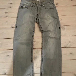 True Religion jeans grå ( sällsynta köpta i Japan) - Säljer ett par grå jeans från True Religion, modell Rocco. Byxorna har klassiska kontrastsömmar och tydliga broderade detaljer på bakfickorna. Tillverkade i bomull med en rak passform och snygga metalldetaljer. Priset är inte hugget i sten skicka gärna bud!